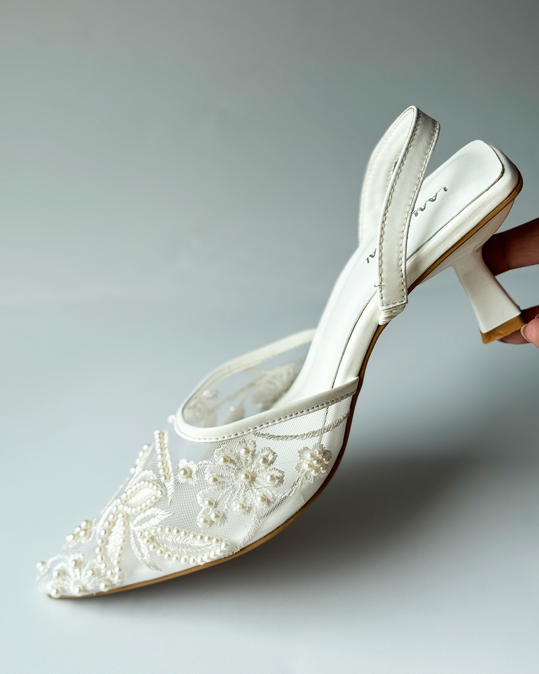 White mesh heels with a pointed toe, finished with fine embroidery and pearl embellishments.