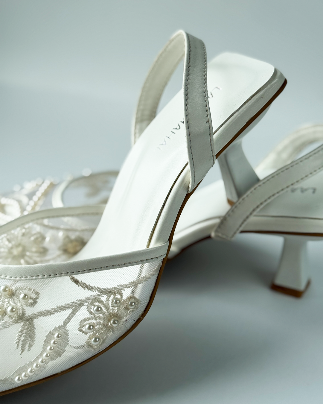 White mesh heels with a pointed toe, finished with fine embroidery and pearl embellishments.