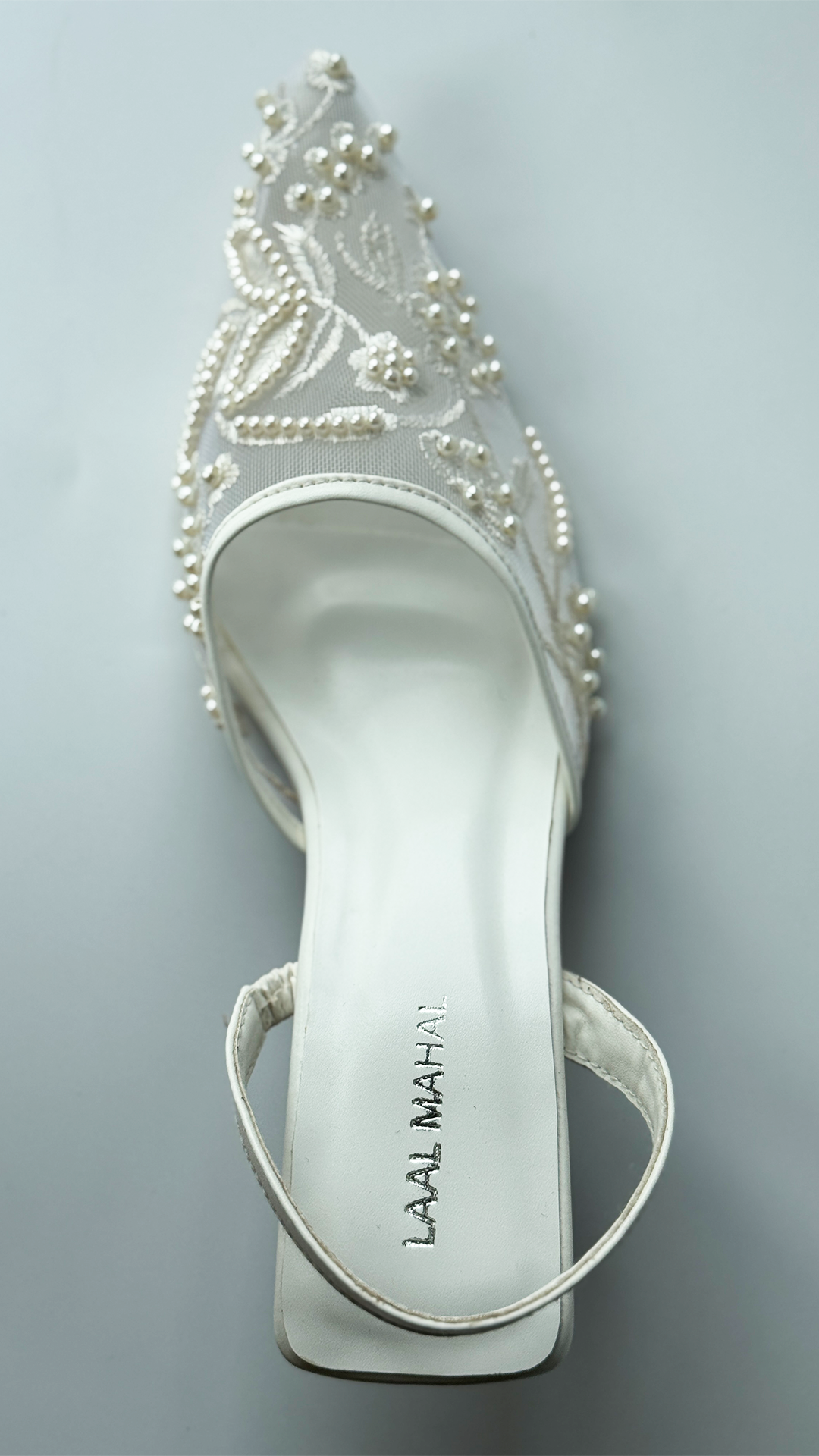 White mesh heels with a pointed toe, finished with fine embroidery and pearl embellishments.