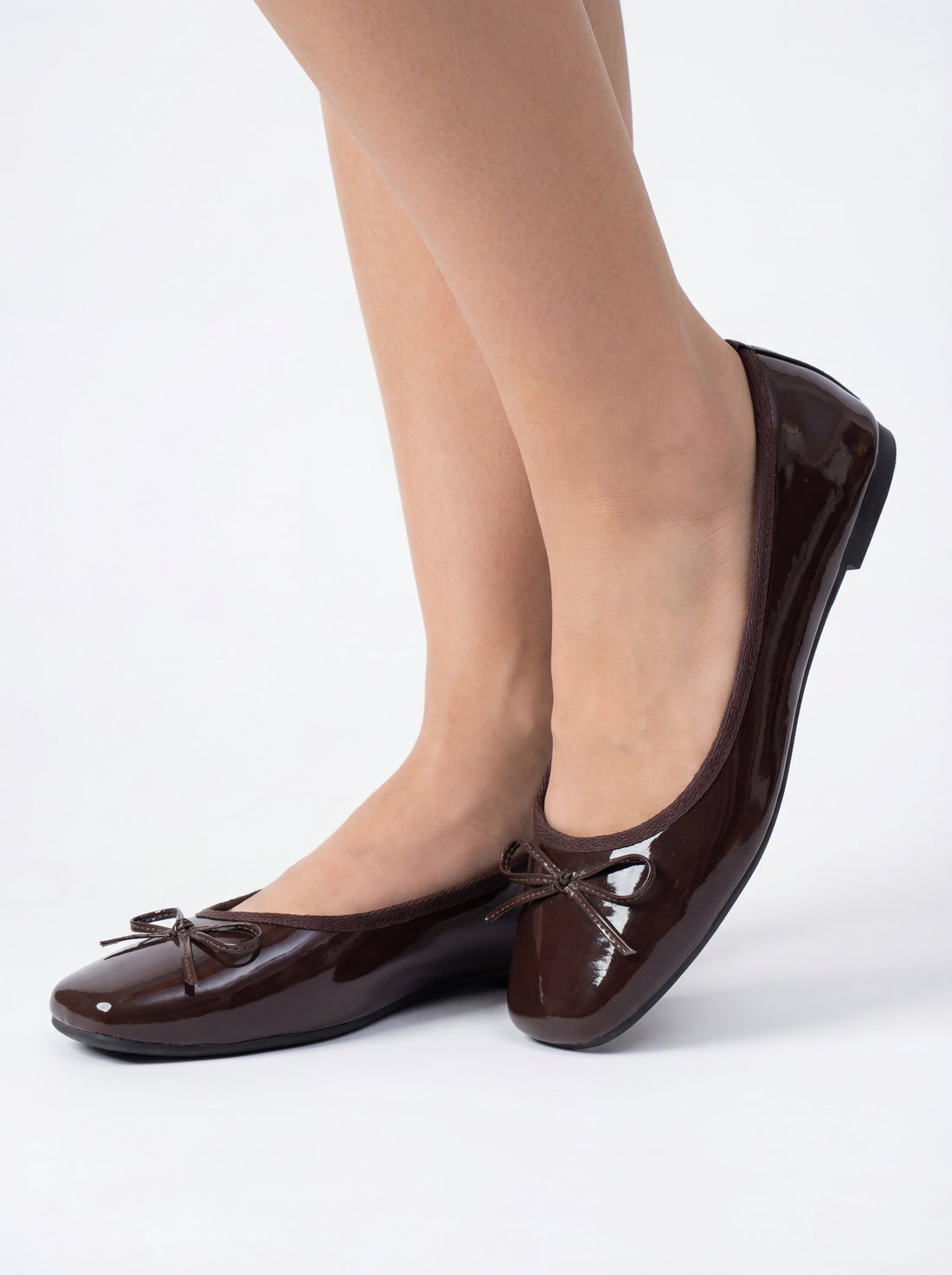 person wearing dark brown bowknot pumps on a white background