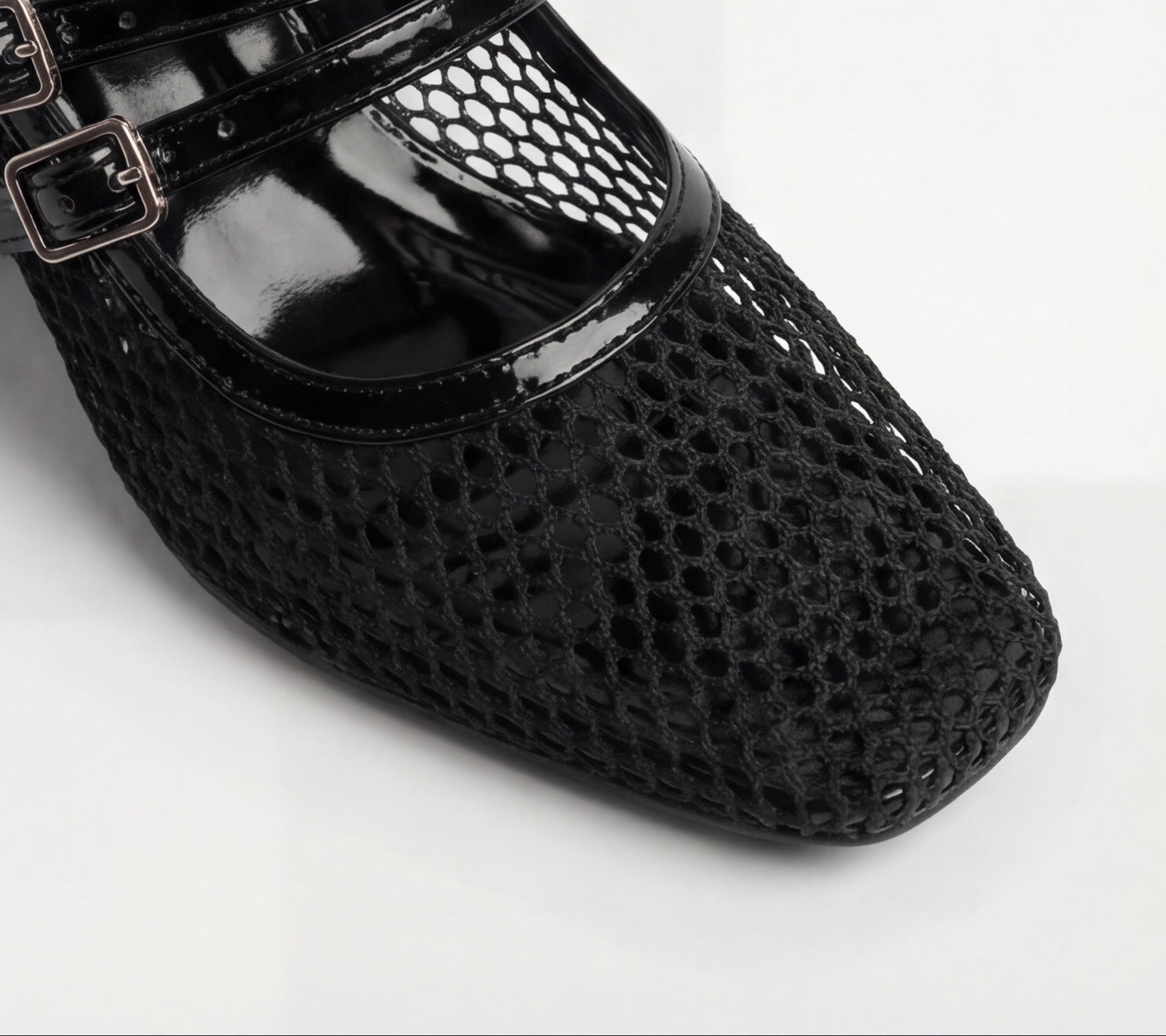 Black shoes with perforated design and buckles on a white background