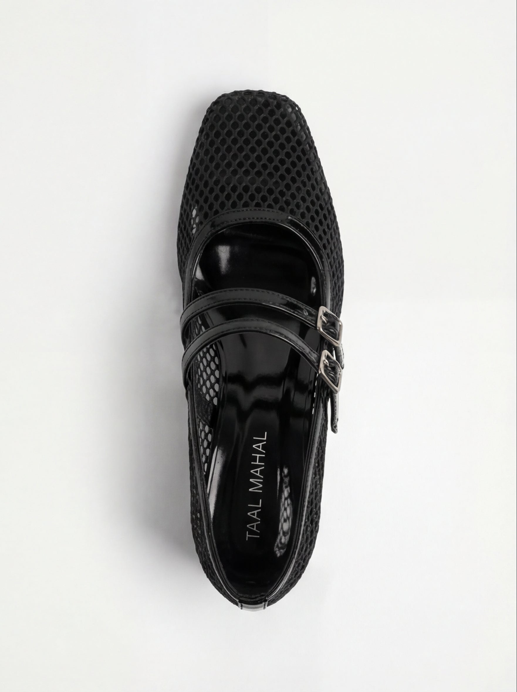 Black shoes with perforated design and buckles on a white background
