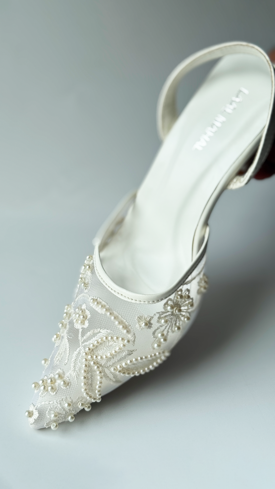 White mesh heels with a pointed toe, finished with fine embroidery and pearl embellishments.