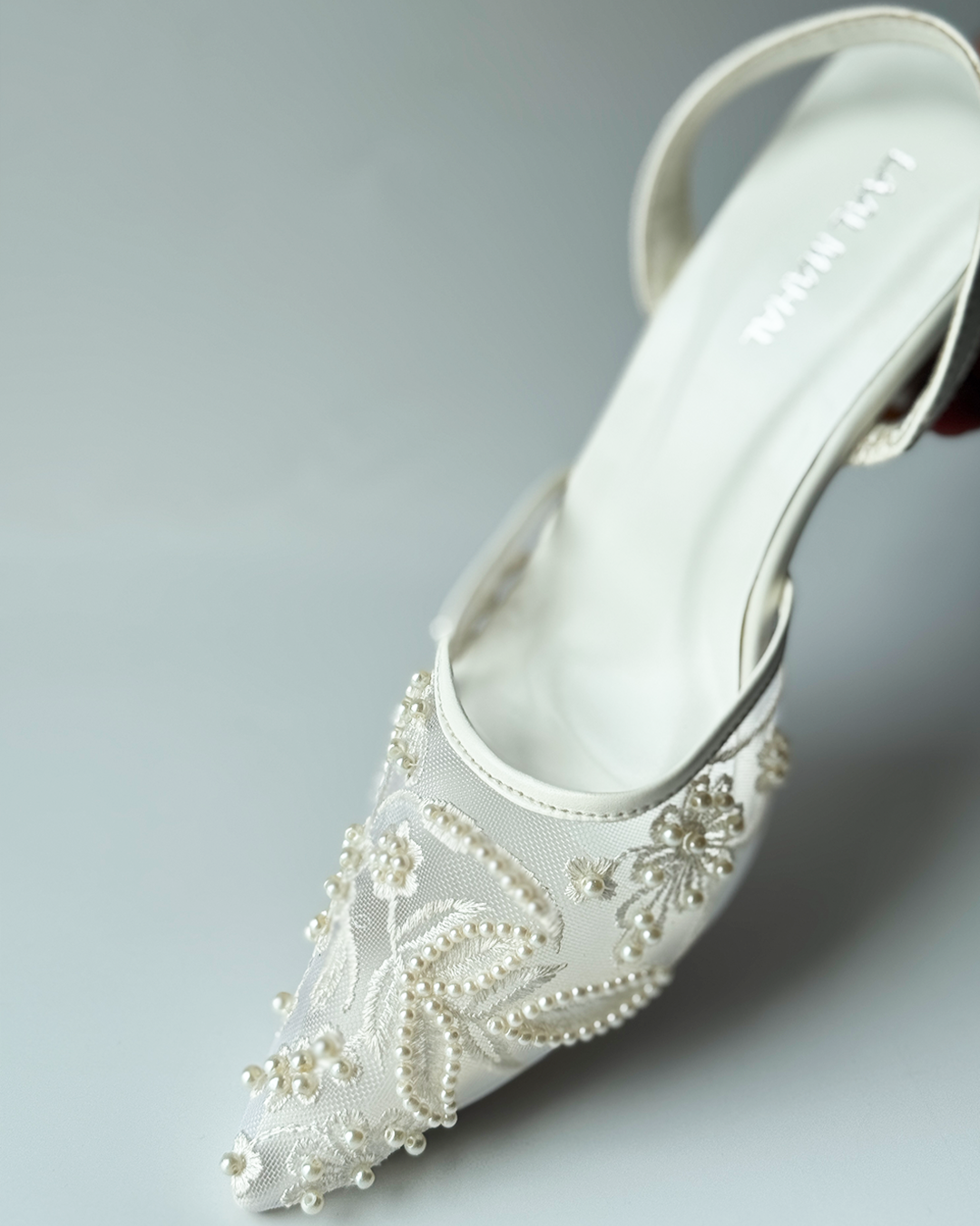 White mesh heels with a pointed toe, finished with fine embroidery and pearl embellishments.