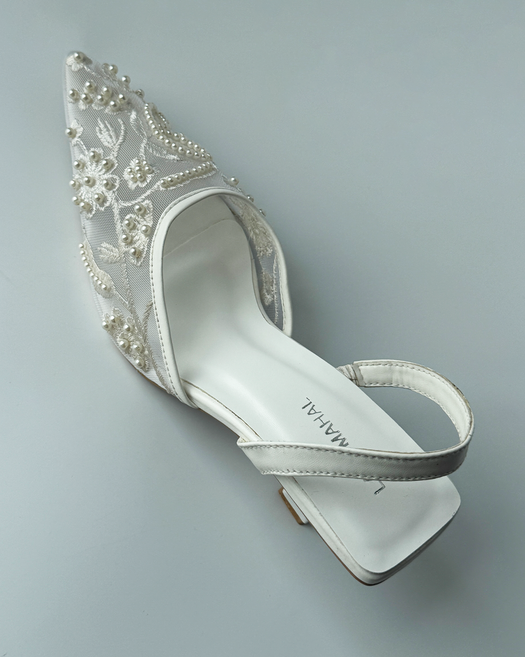 White mesh heels with a pointed toe, finished with fine embroidery and pearl embellishments.