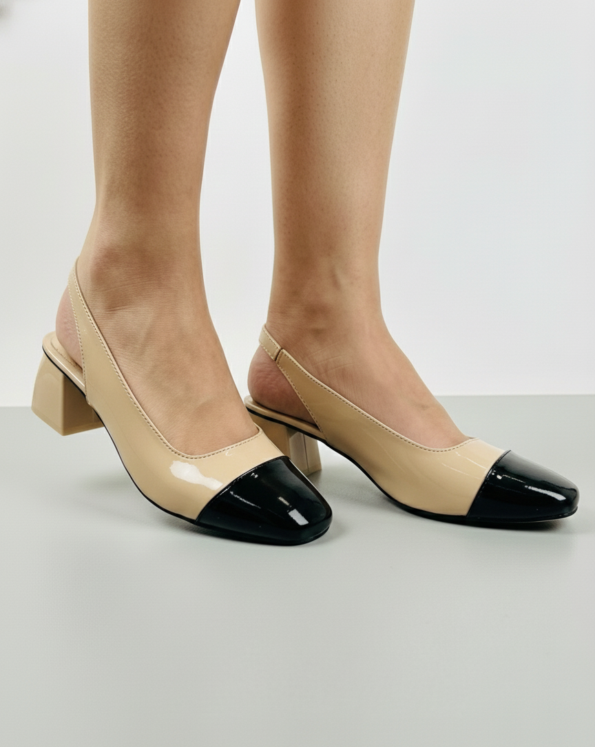 Beige and black slingback block heels on a neutral background