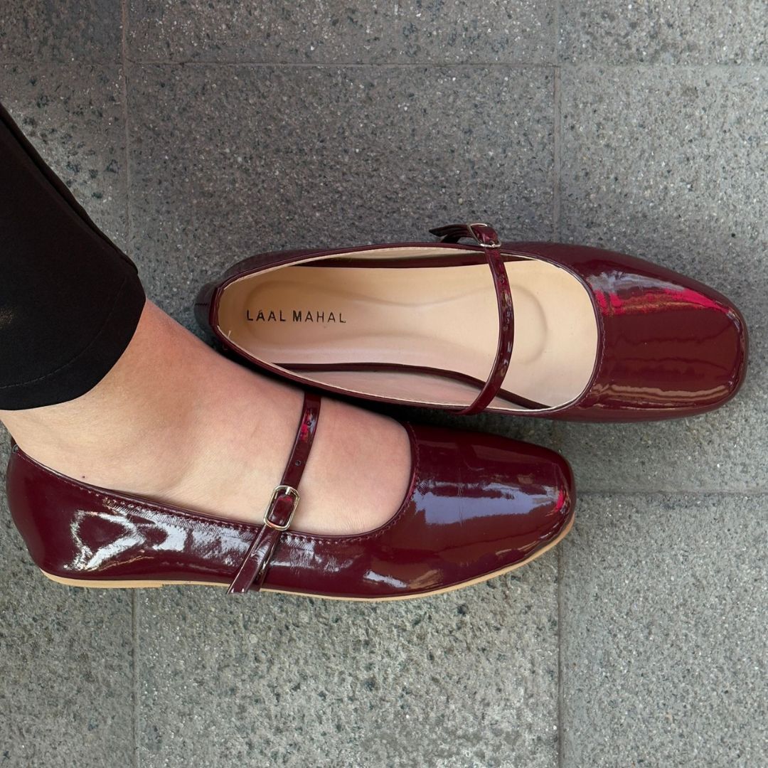 Bella burgundy patent leather mary jane flat shoes worn on feet overhead street view Pakistan — Laal Mahal