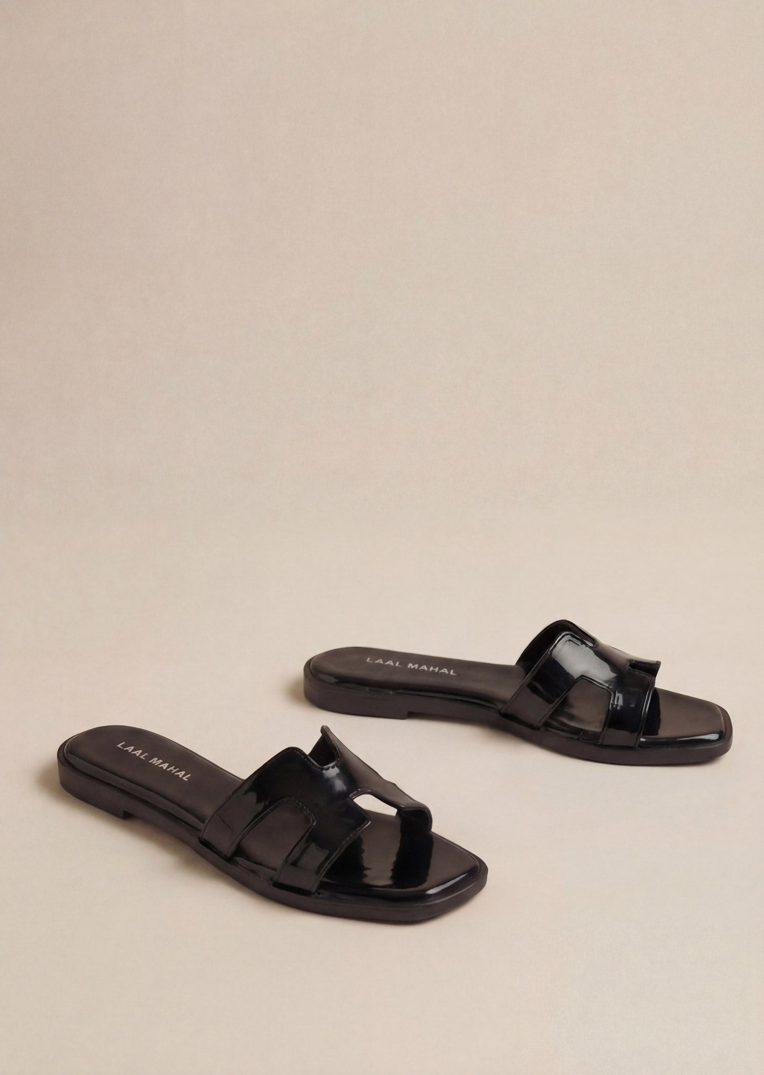 Glossy Black patent H-strap slide flat sandals pair on beige background women Pakistan – Laal Mahal