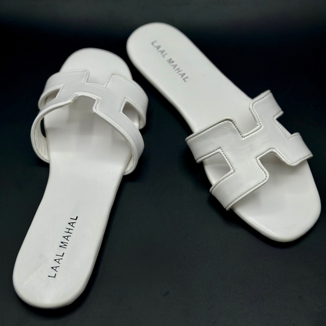 Women’s white H-style flat sandals with cut-out straps, non-slip sole, and detailed stitching, product flat-lay on dark background.