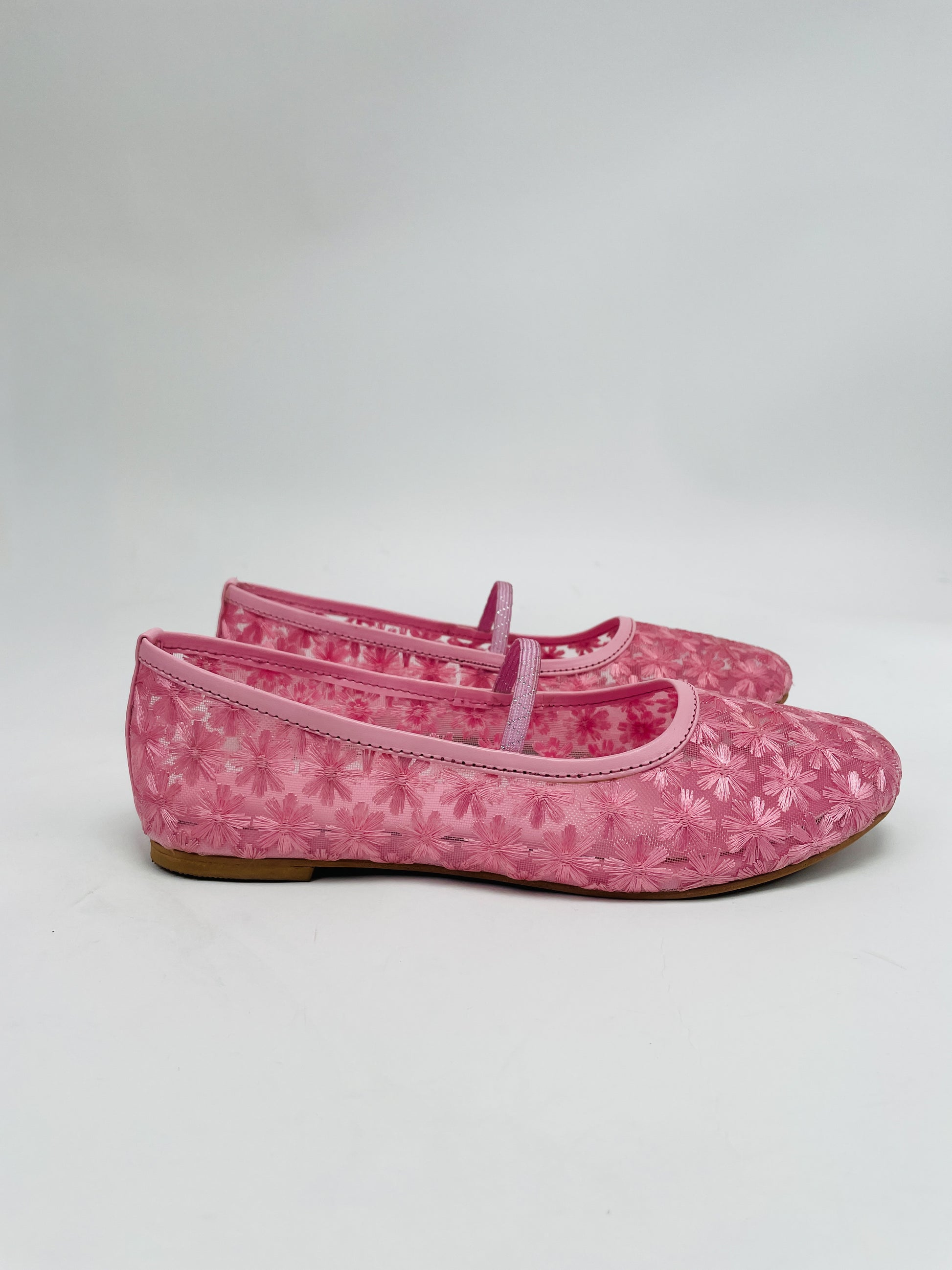 Pair of pink floral-patterned shoes on a white background