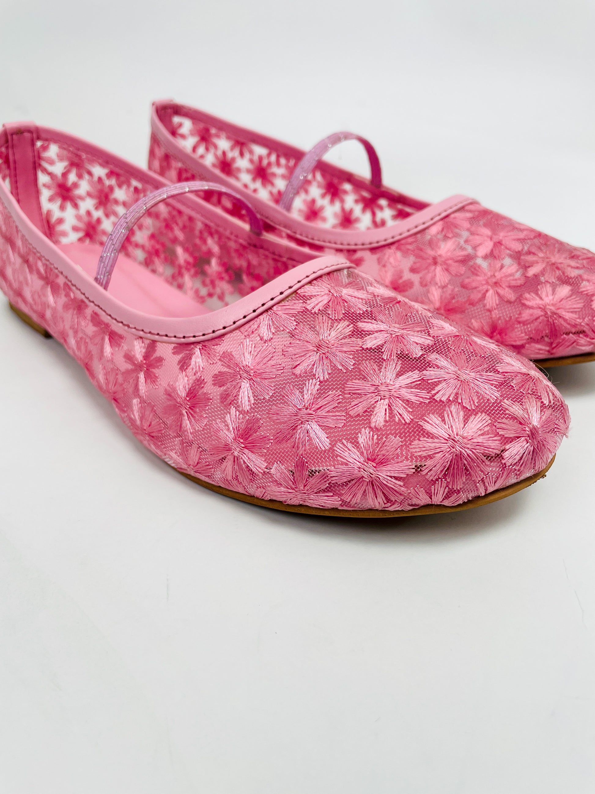 Pink floral-patterned shoes on a white background