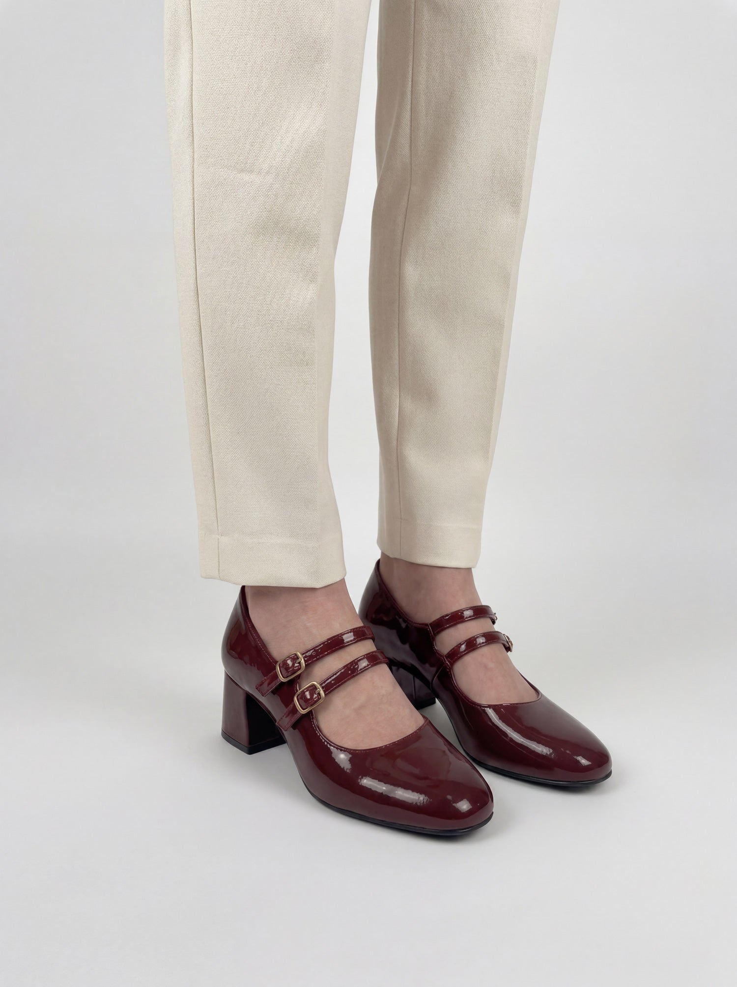 Woman wearing maroon patent leather Mary Jane heels with double buckle strap – Laal Mahal Pakistan