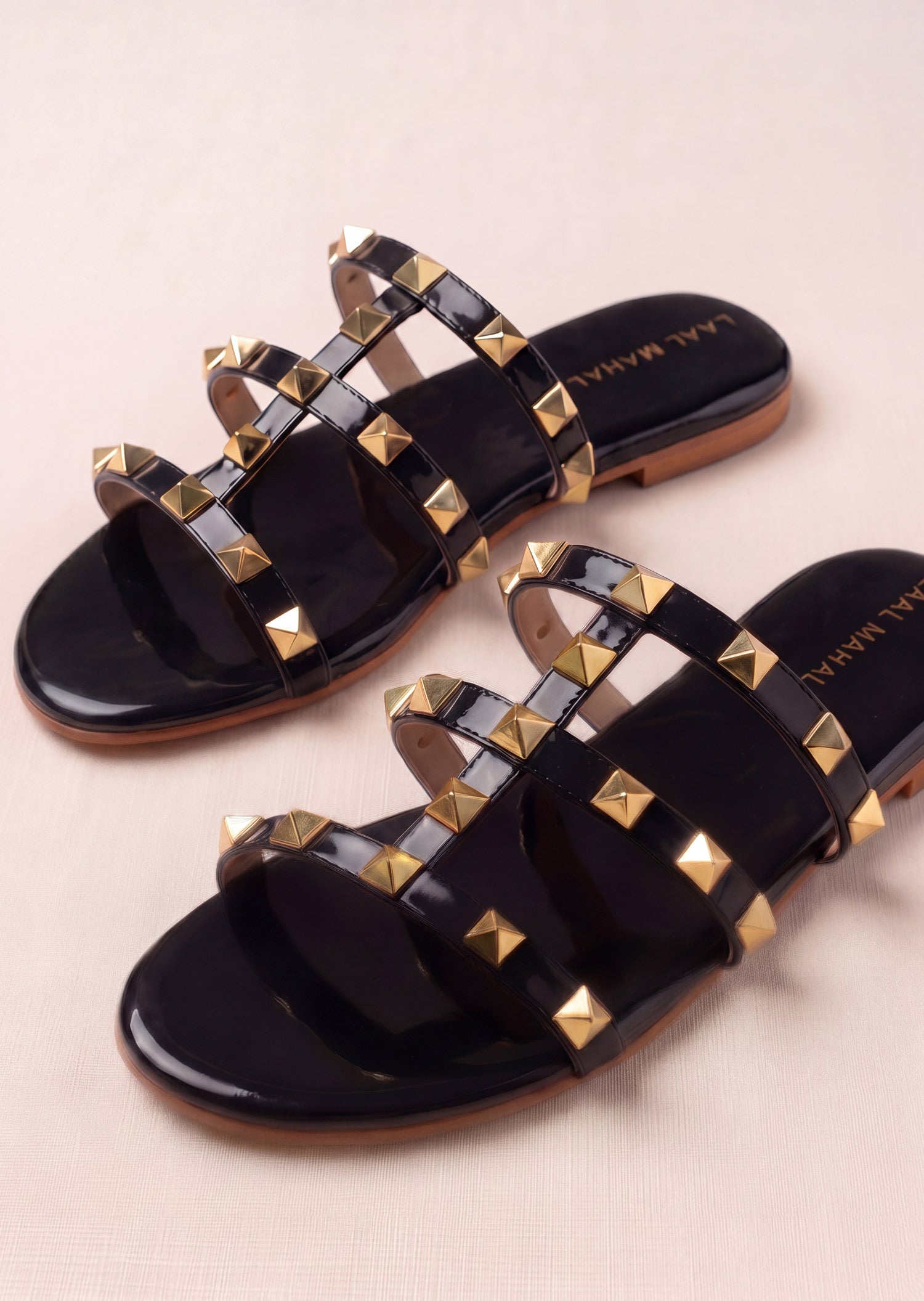 Laal Mahal Rockstud Flat Slide Sandals black patent pair angled view showing gold pyramid studs on triple straps – women's summer sandals Pakistan
