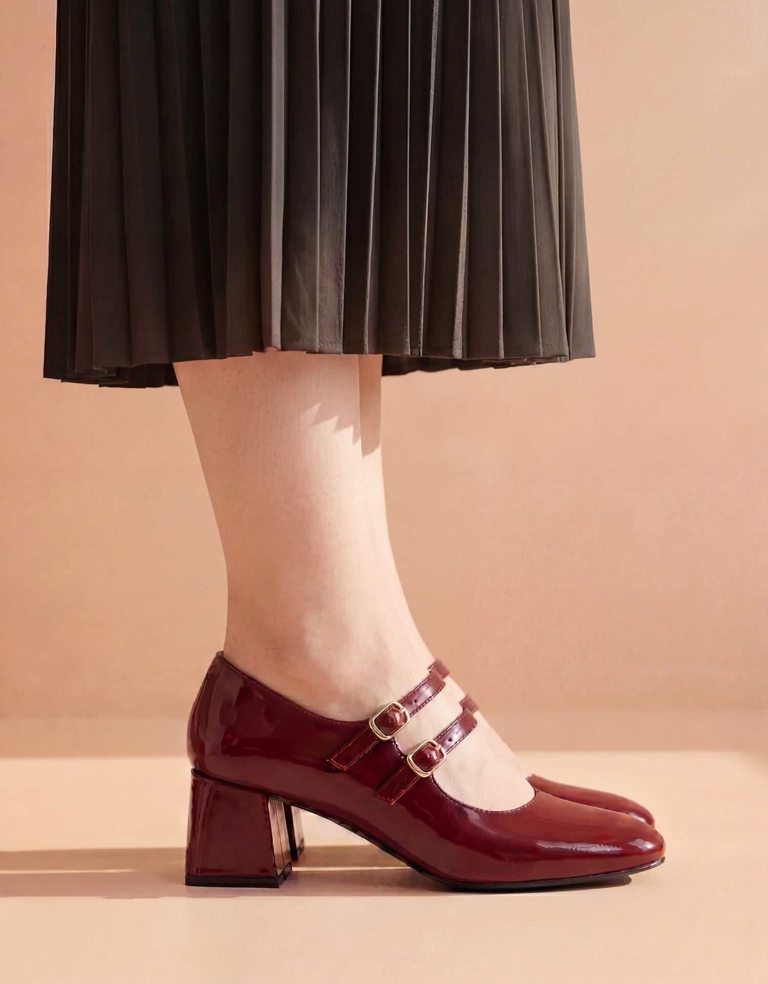 Woman wearing maroon patent leather Mary Jane heels with double buckle strap – Laal Mahal Pakistan