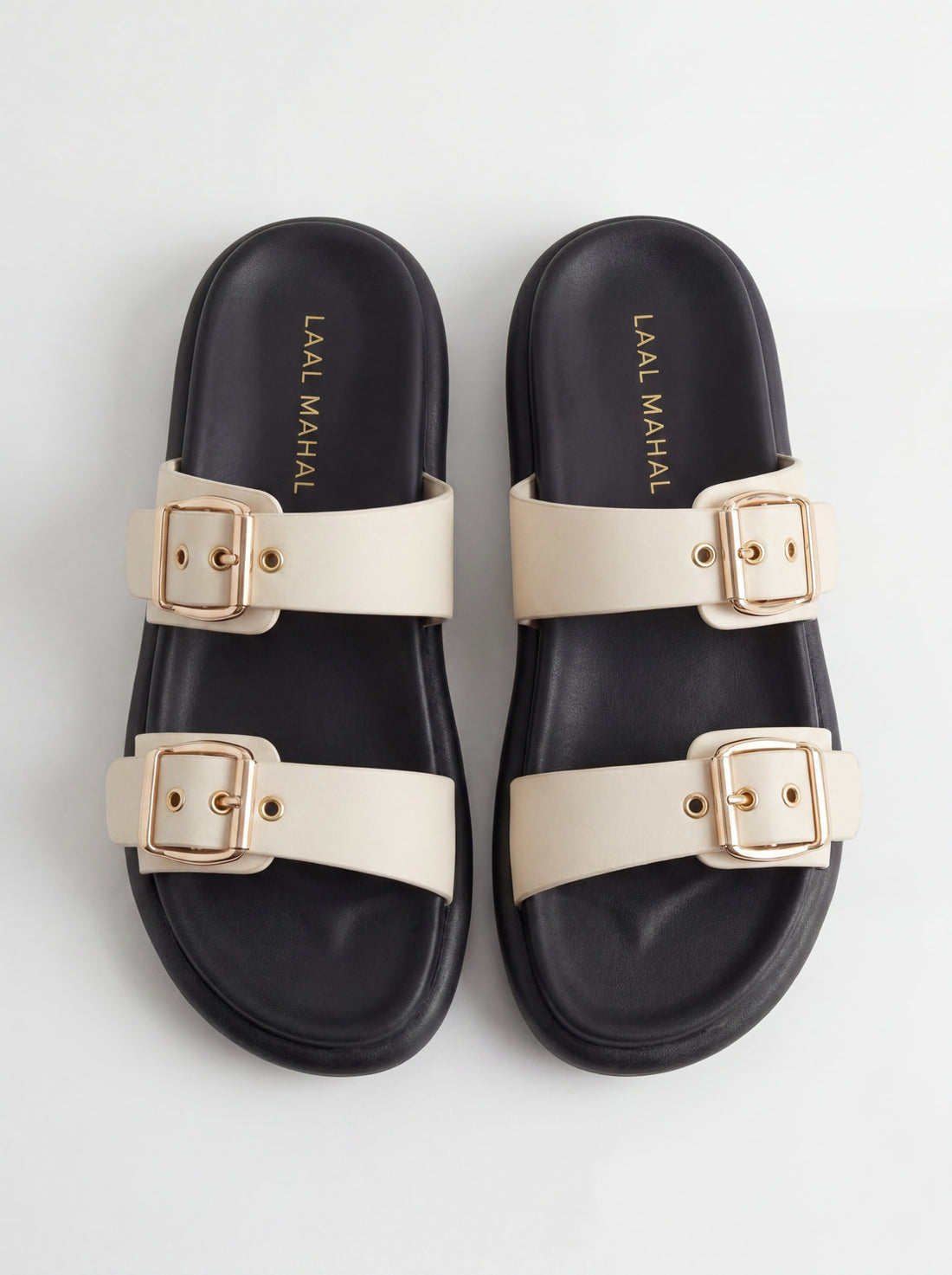 Beige sandals worn with a beige skirt on a light background